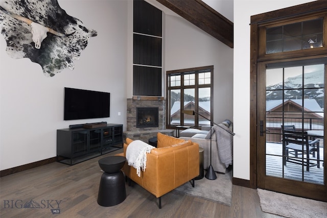 living room with a fireplace, high vaulted ceiling, a mountain view, beam ceiling, and dark hardwood / wood-style flooring