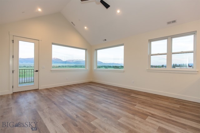 unfurnished room featuring light hardwood / wood-style floors and high vaulted ceiling