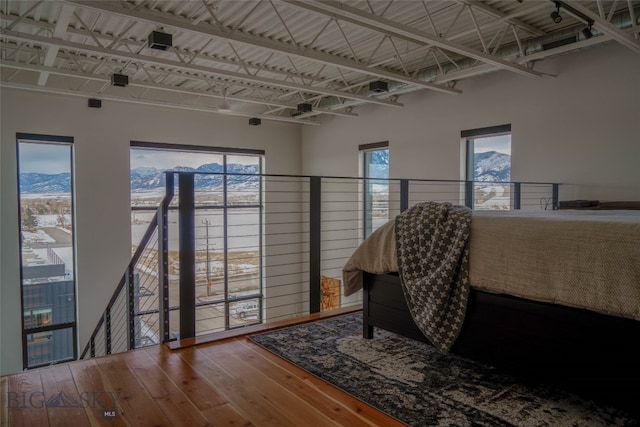 bedroom with a high ceiling and hardwood / wood-style flooring