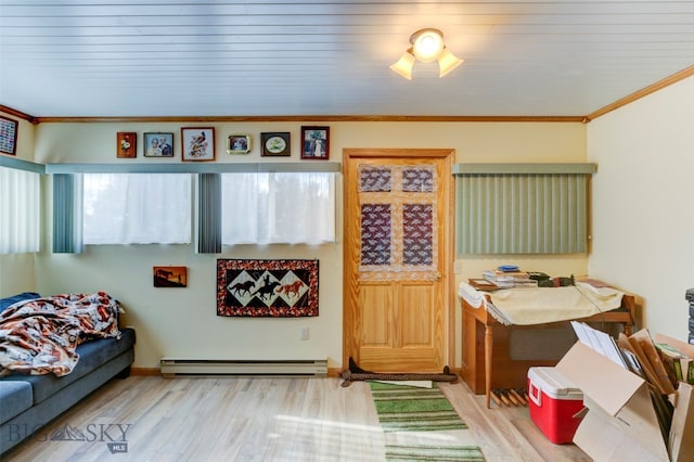 interior space featuring light hardwood / wood-style flooring, ornamental molding, and a baseboard heating unit