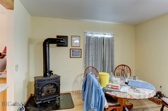 dining space featuring a wood stove and wood-type flooring