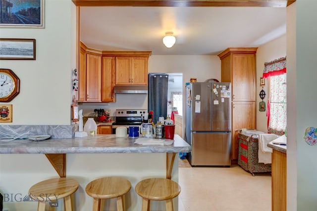 kitchen featuring kitchen peninsula, appliances with stainless steel finishes, and a breakfast bar area