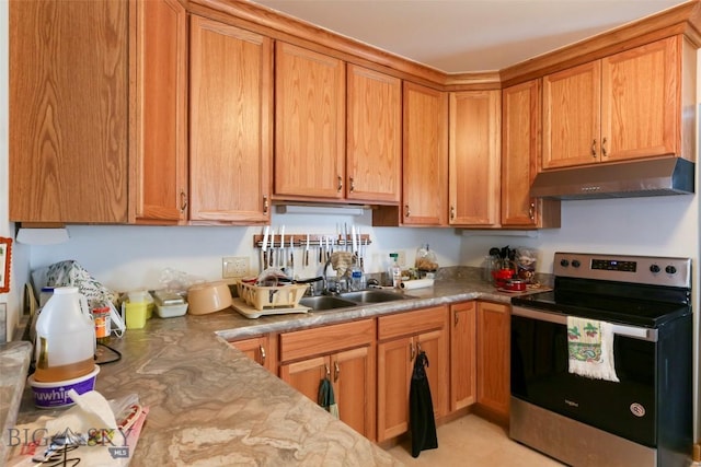 49 Two Dot Hwy, Harlowton, MT 59085 - kitchen with under cabinet range hood, brown cabinets, stainless steel electric stove, and a sink