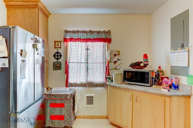 kitchen with light brown cabinetry, heating unit, and appliances with stainless steel finishes