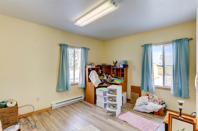 misc room with baseboard heating, plenty of natural light, and light hardwood / wood-style floors