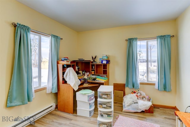 interior space featuring a wealth of natural light, baseboard heating, and hardwood / wood-style flooring