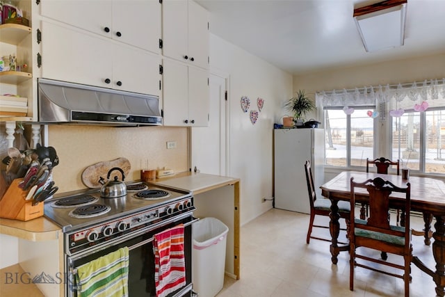 kitchen featuring electric range oven, white cabinets, and white fridge