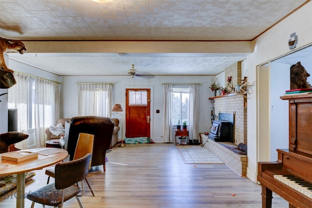 living room featuring crown molding, a fireplace, and light hardwood / wood-style flooring