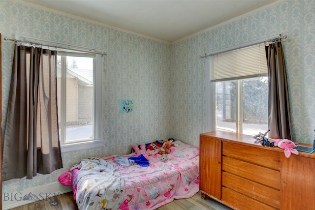 bedroom with light hardwood / wood-style floors and multiple windows