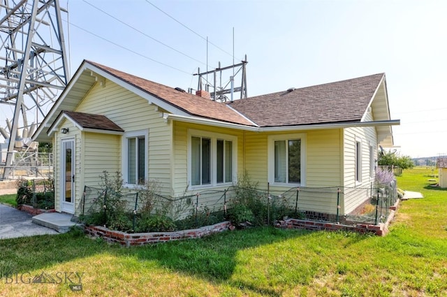 49 Two Dot Hwy, Harlowton, MT 59085 - view of side of home featuring a yard, a shingled roof, and fence
