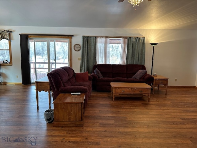 living room featuring ceiling fan, dark wood-type flooring, and a healthy amount of sunlight