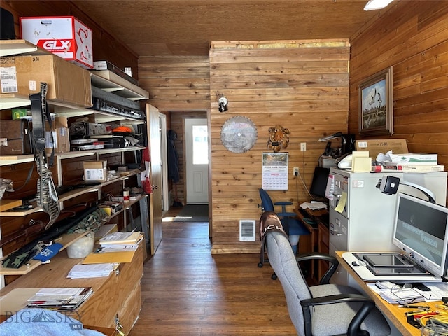 office area with dark hardwood / wood-style flooring and wooden walls