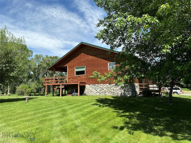 view of side of property featuring a wooden deck and a lawn