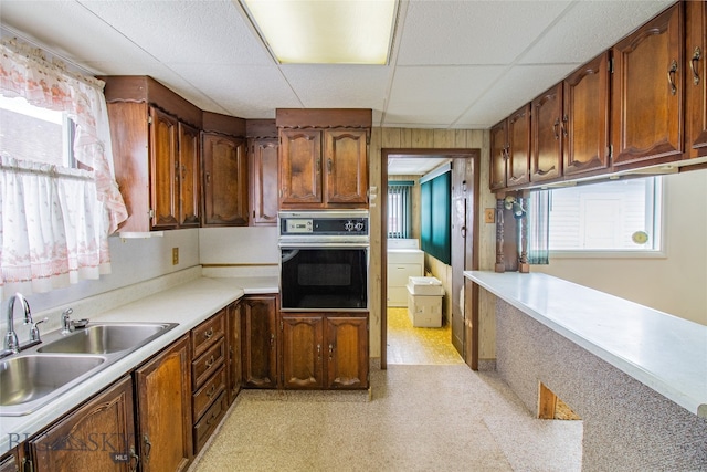 kitchen featuring sink, a paneled ceiling, a wealth of natural light, and oven