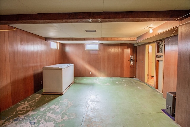 basement featuring fridge and wood walls