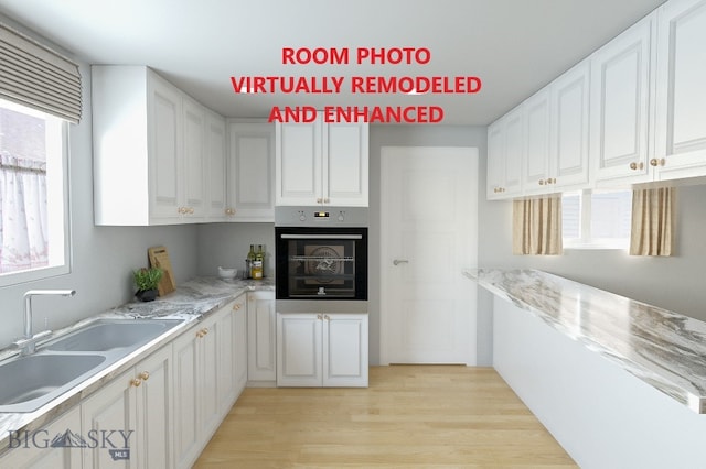 kitchen featuring wall oven, white cabinetry, a wealth of natural light, and light wood-type flooring