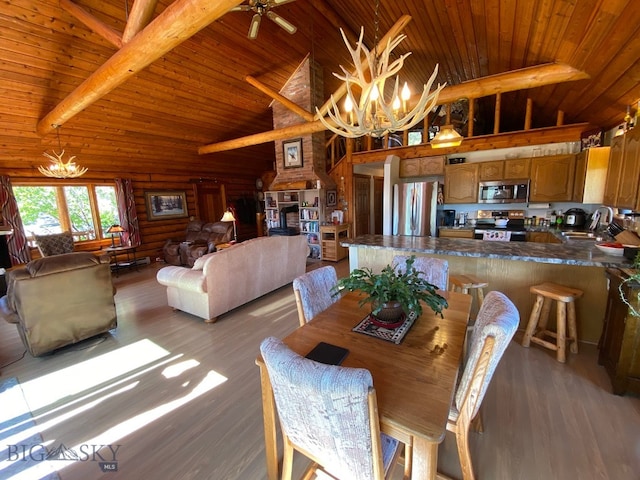 dining area with light hardwood / wood-style floors, vaulted ceiling with beams, log walls, wood ceiling, and ceiling fan with notable chandelier