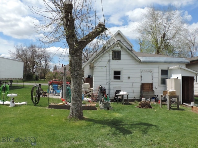 rear view of house featuring a lawn