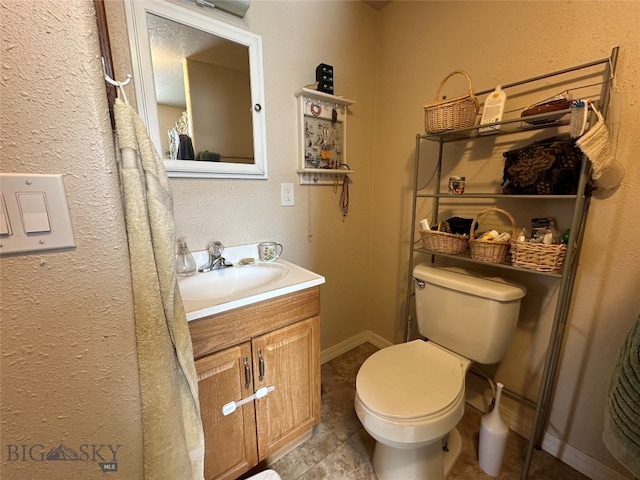 bathroom with vanity, toilet, and tile floors