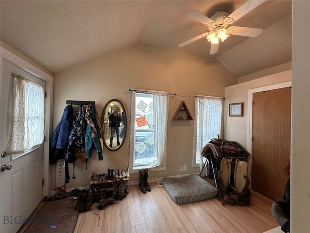 foyer entrance with light hardwood / wood-style flooring, ceiling fan, and vaulted ceiling