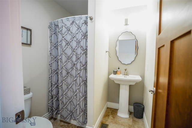 bathroom featuring sink, tile floors, and toilet