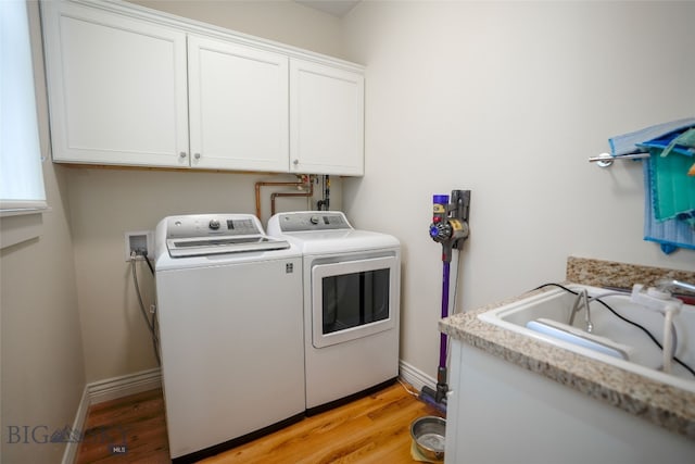 washroom with light hardwood / wood-style flooring, washing machine and clothes dryer, cabinets, and hookup for a washing machine