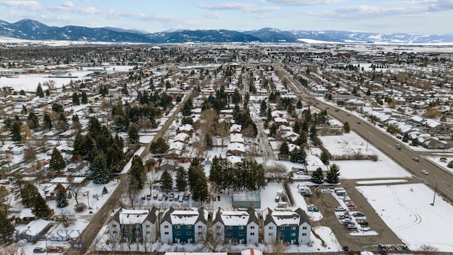 snowy aerial view featuring a residential view and a mountain view