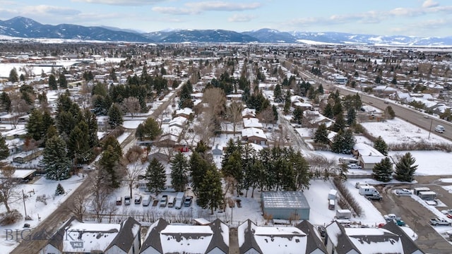 snowy aerial view featuring a residential view and a mountain view