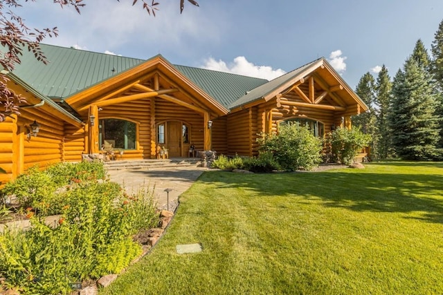 log home featuring metal roof, log exterior, and a front yard