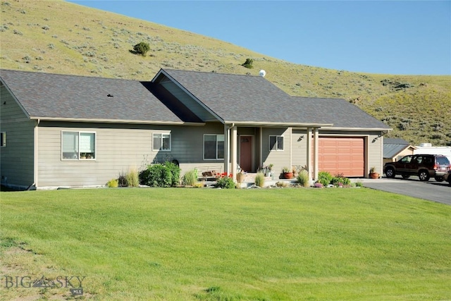 ranch-style house featuring a garage and a front lawn