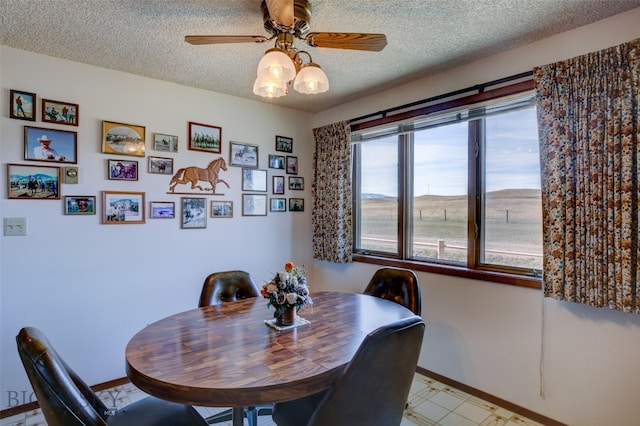 dining space featuring ceiling fan and a textured ceiling