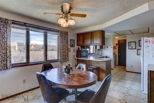 dining room with washer / dryer, a textured ceiling, ceiling fan, and sink