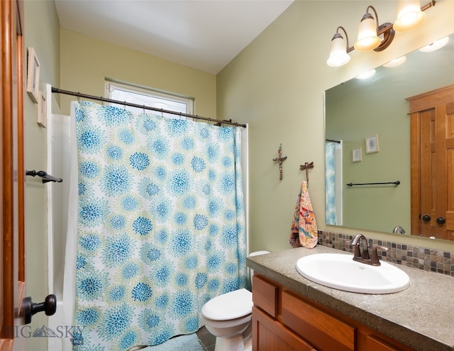 bathroom featuring toilet, decorative backsplash, and vanity