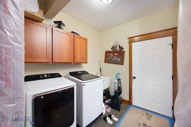 laundry room with light tile patterned flooring, independent washer and dryer, and cabinets