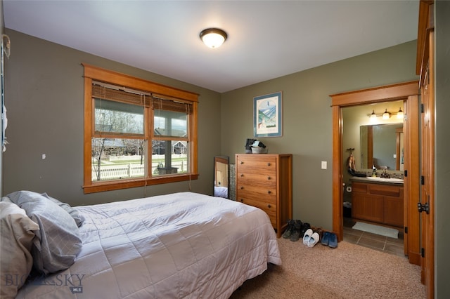 bedroom featuring sink, connected bathroom, and light tile patterned floors