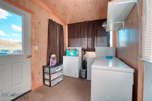 laundry area featuring wood walls and separate washer and dryer