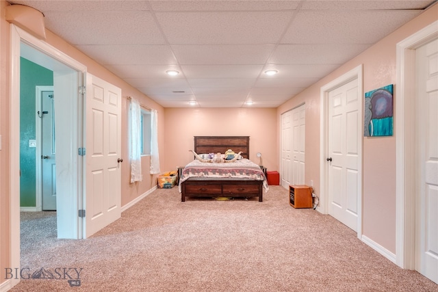 bedroom with light carpet and a paneled ceiling