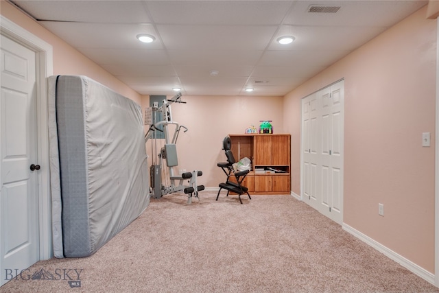 exercise room with a drop ceiling and light carpet