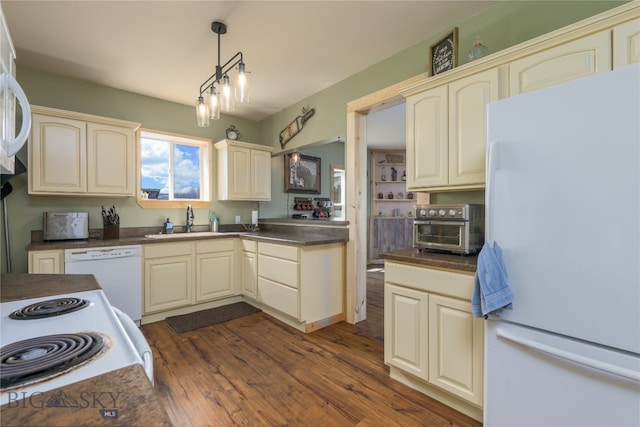 kitchen featuring a notable chandelier, white appliances, dark hardwood / wood-style floors, sink, and pendant lighting