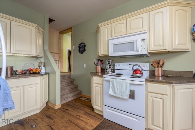 kitchen featuring cream cabinets, white appliances, and dark hardwood / wood-style floors