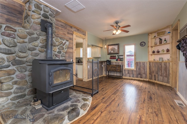 interior space featuring wooden walls, a wood stove, and dark hardwood / wood-style floors