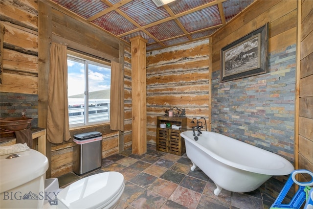 bathroom with wood walls, toilet, a bathing tub, and wooden ceiling