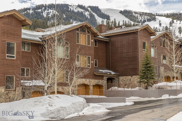 snow covered building featuring a mountain view