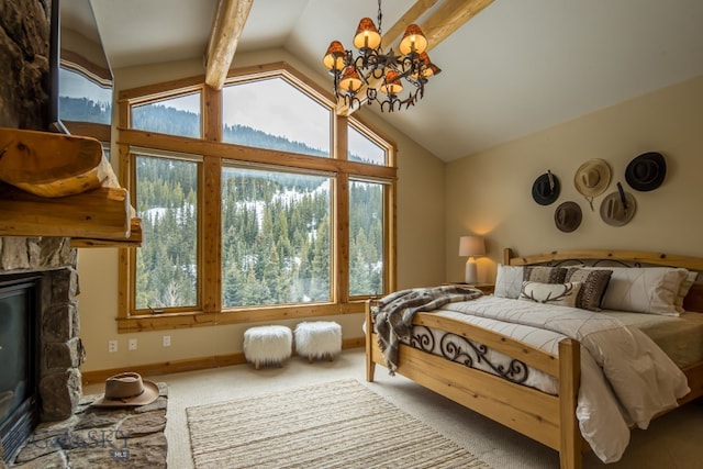 carpeted bedroom with multiple windows, lofted ceiling with beams, and a stone fireplace