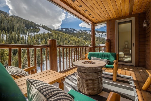 deck with an outdoor fire pit and a mountain view