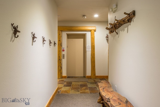 hall featuring dark colored carpet and elevator