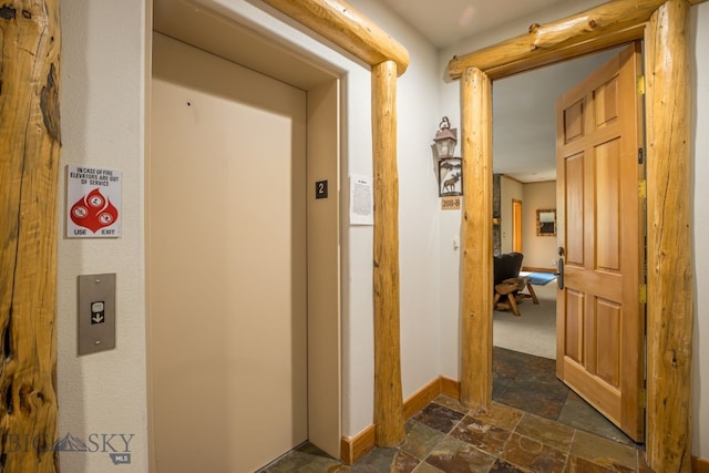 hall with elevator and dark tile flooring