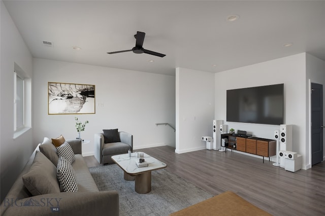 living room featuring dark wood-type flooring and ceiling fan