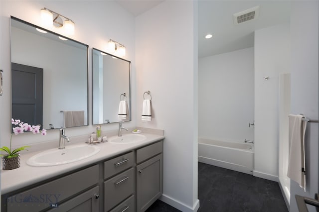 bathroom with a tub to relax in, vanity, and tile patterned flooring