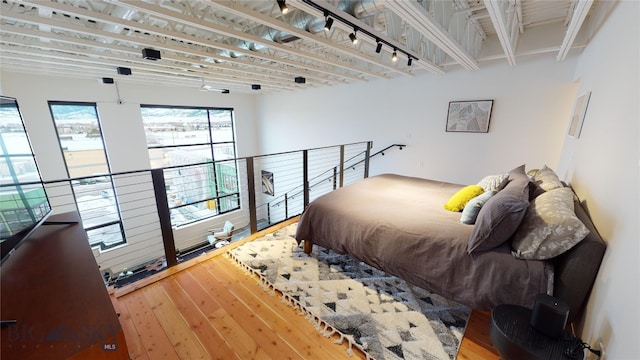 bedroom featuring rail lighting and wood-type flooring